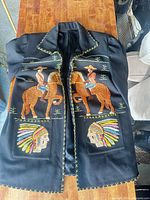 Front view showing embroidered cowboys on horseback and Native American profiles