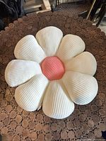Top view of the flower-shaped plush pillow showing petal design and center color