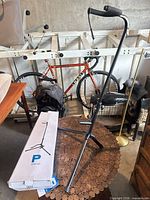 Guitar stand assembled next to its branded box showing full structure