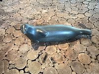 Top and side view of polished dark stone seal carving
