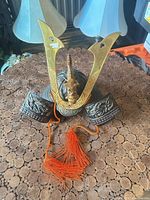 Front view of the miniature samurai helmet showing crest, dragon ornament and tassel