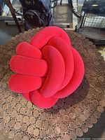 Red knot plush pillow on cork surface showing overall form