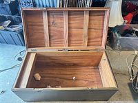 Chest interior with lid open showing wood interior panels and hinges