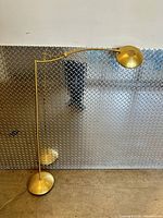 Full view of brass adjustable floor lamp showing height, base, arm, shade