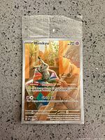 Front view of sealed Mimikyu promo card showing artwork, stats and sealed sleeve