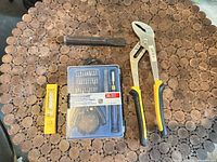 All items in lot on table: pliers, Mastercraft bit set, chisel, yellow case