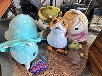 Group view of all six plush items on cork tabletop