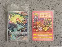 Front view of sealed Scream Tail promo card alongside Taipei promotional flyer on countertop