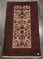 Full view of Baluchi rug showing complete design and fringes