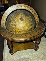 Oblique view of globe showing map detail and wood stand