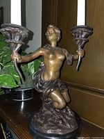full view of bronze figural candelabra with candles