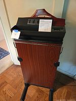Full front view of Brookstone trouser press showing wood veneer panel, control panel, and hanger