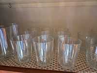 cabinet view showing group of tall and short faceted clear glasses