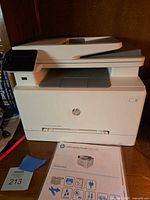 Front view of HP Color LaserJet Pro MFP printer with setup sheet