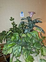 Three faux plants grouped together showing foliage shapes