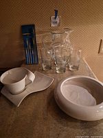 Group shot showing pitcher, glasses, bowl, cup with plate, and fondue forks box