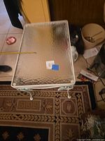 Rectangular side table with textured glass top and white metal frame visible