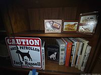 Overall shot showing sign, books and playing card tins on shelves