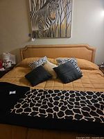 Overall view of bed showing headboard, bedspread, throw blanket and pillows