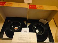 Two Kodak Carousel 140 slide trays inside open boxes with paperwork visible