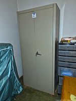 Full view of tall beige metal cabinet, closed doors