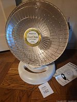 Front view of Presto HeatDish Plus Footlight heater on base with manual beside