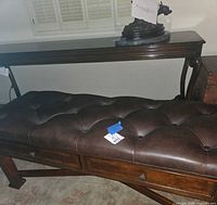 Full view of bench showing leather tufted top and drawers