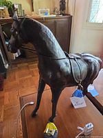 Front angle of leather-covered horse showing saddle, bridle, reins