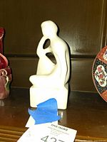 Front view of white abstract seated figurine
