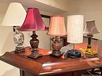 Five lamps displayed side by side on wooden surface