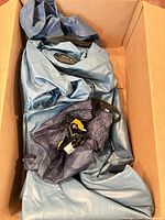 Deflated blue air mattress and accessories inside carton