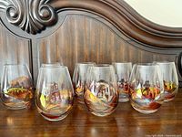 Set of eight stemless glasses displayed in a row