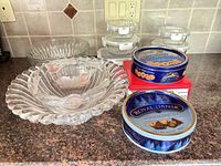 Group shot showing one frosted lily bowl, pedestal bowl partially, storage containers stack, and cookie tins