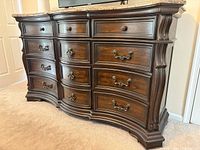 Front view showing marble top, serpentine shape, drawer arrangement, hardware