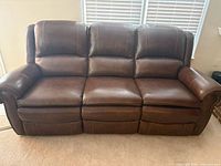 Front view of chestnut leather three-seat power reclining sofa