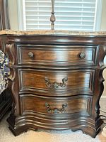 Front view showing three drawers, curved front, hardware, finish