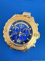 Front view showing blue multi-register dial, gold-tone bezel and case