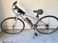Full left side view of K2 silver/pink hybrid bicycle with accessories attached