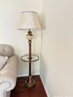 Full view of lamp beside sofa showing shade, pole, tray table, base