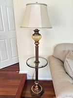 Full view of floor lamp beside sofa showing shade, pole, glass tray, base