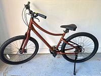 Full left-side view of the bicycle showing frame color, wheel size, disc brakes, handlebars, saddle and kickstand