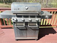 Front view of Monument 4-burner stainless steel propane grill on deck
