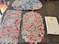 Rectangular red placemats, round blue placemats, packaged tablecloth displayed on table