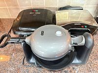 Group shot: George Foreman grill, Krups waffle maker, Dash waffle maker in stand