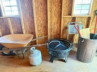 Wheelbarrow, propane tank, fire pit, trash can with tools