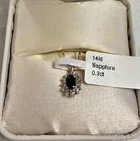 Pendant in box with tag showing 14kt Sapphire 0.3ct