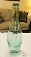 Front view of aqua glass torpedo bottle showing "STANLEY" embossing and overall shape