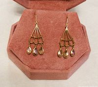 Front view of the pair of 18K yellow gold chandelier earrings with three zultanite drops each