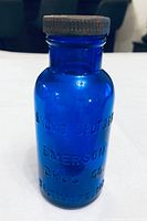 Front view of cobalt blue Bromo-Seltzer bottle showing embossing and cap
