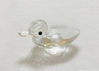 Overall view of the faceted crystal duck figurine showing head, beak, body and pedestal base